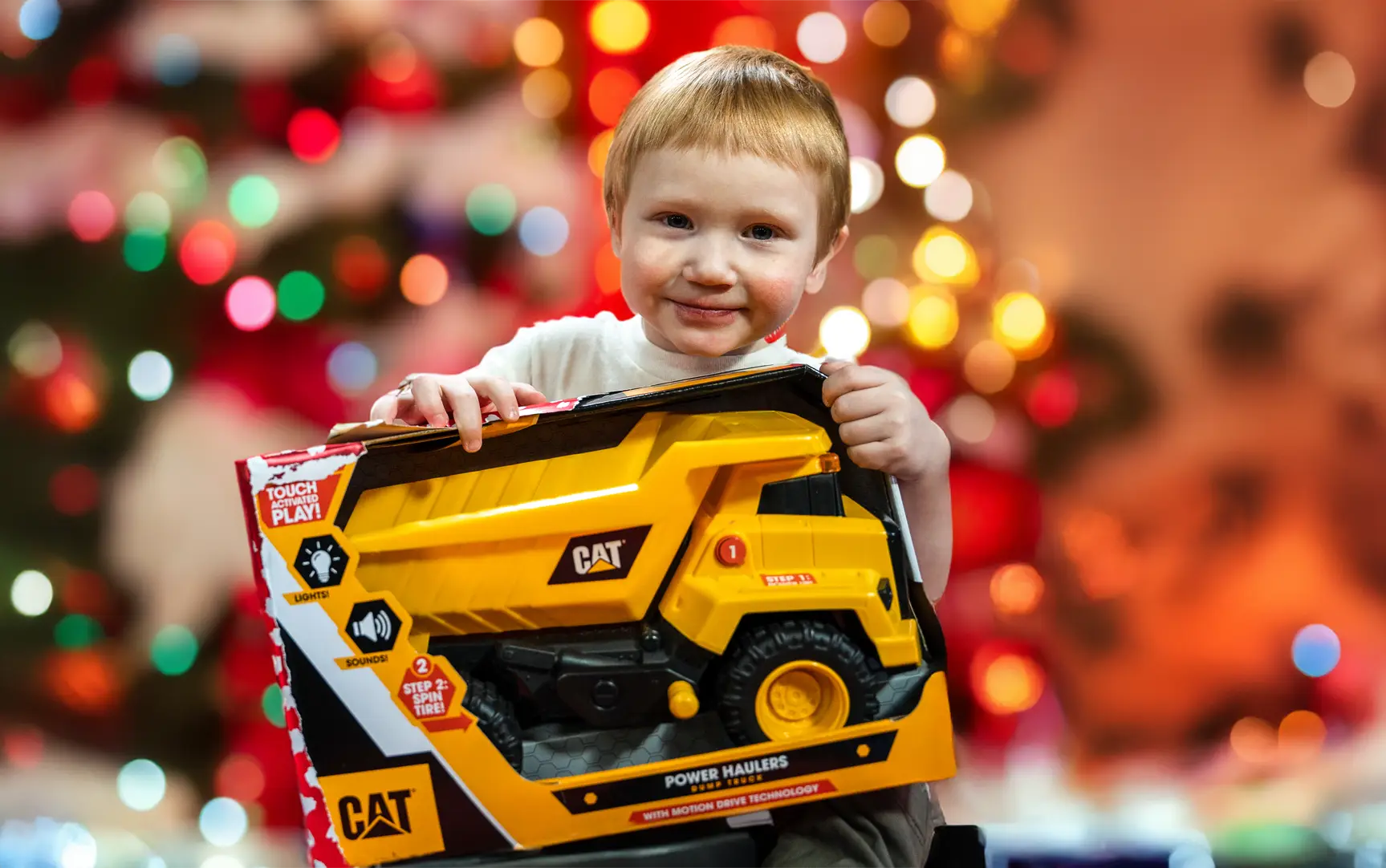 Child holding a truck Christmas gift from the Precious Gift drive