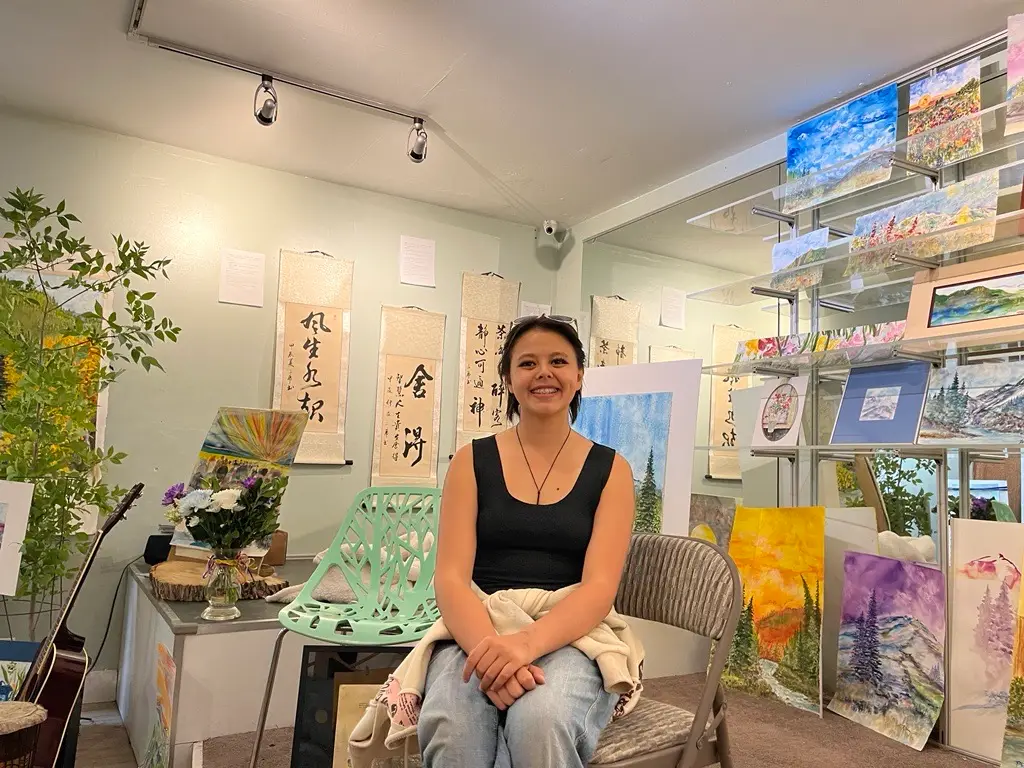 Hansa smiling in a room of her beautiful art.